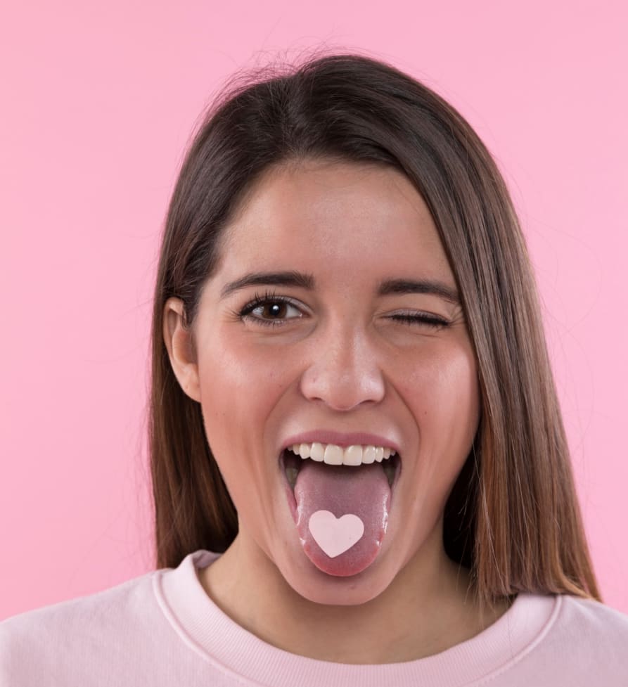 Woman sticking out her tongue with a heart shape on it