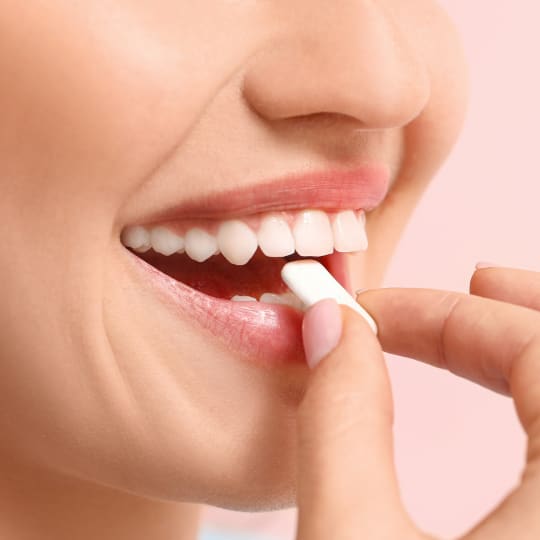 Woman biting sugar free chewing gum