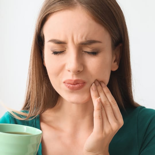 A women in pain holding her cheek