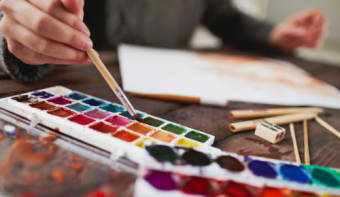 multicoloured paints and paintbrush